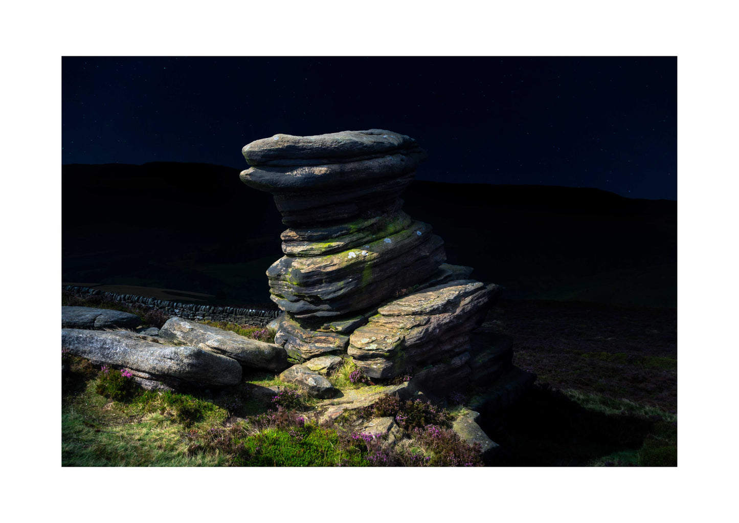Stack of stones in a natural landscape with a dark sky