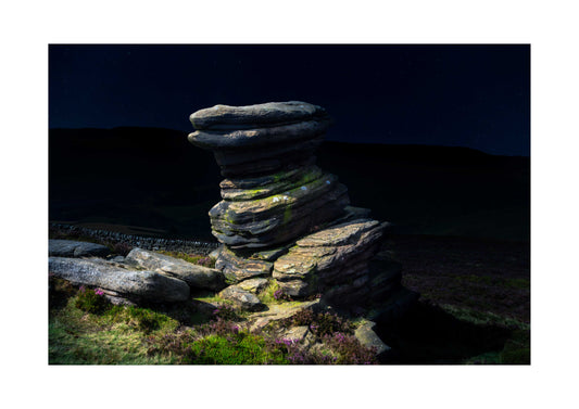 Stack of stones in a natural landscape with a dark sky
